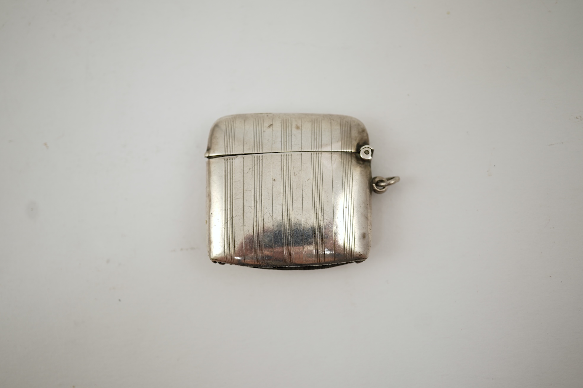 A George V silver and enamel vesta case, by Henry Hyde Aston, the inset circular enamel plaque decorated with a French bulldog